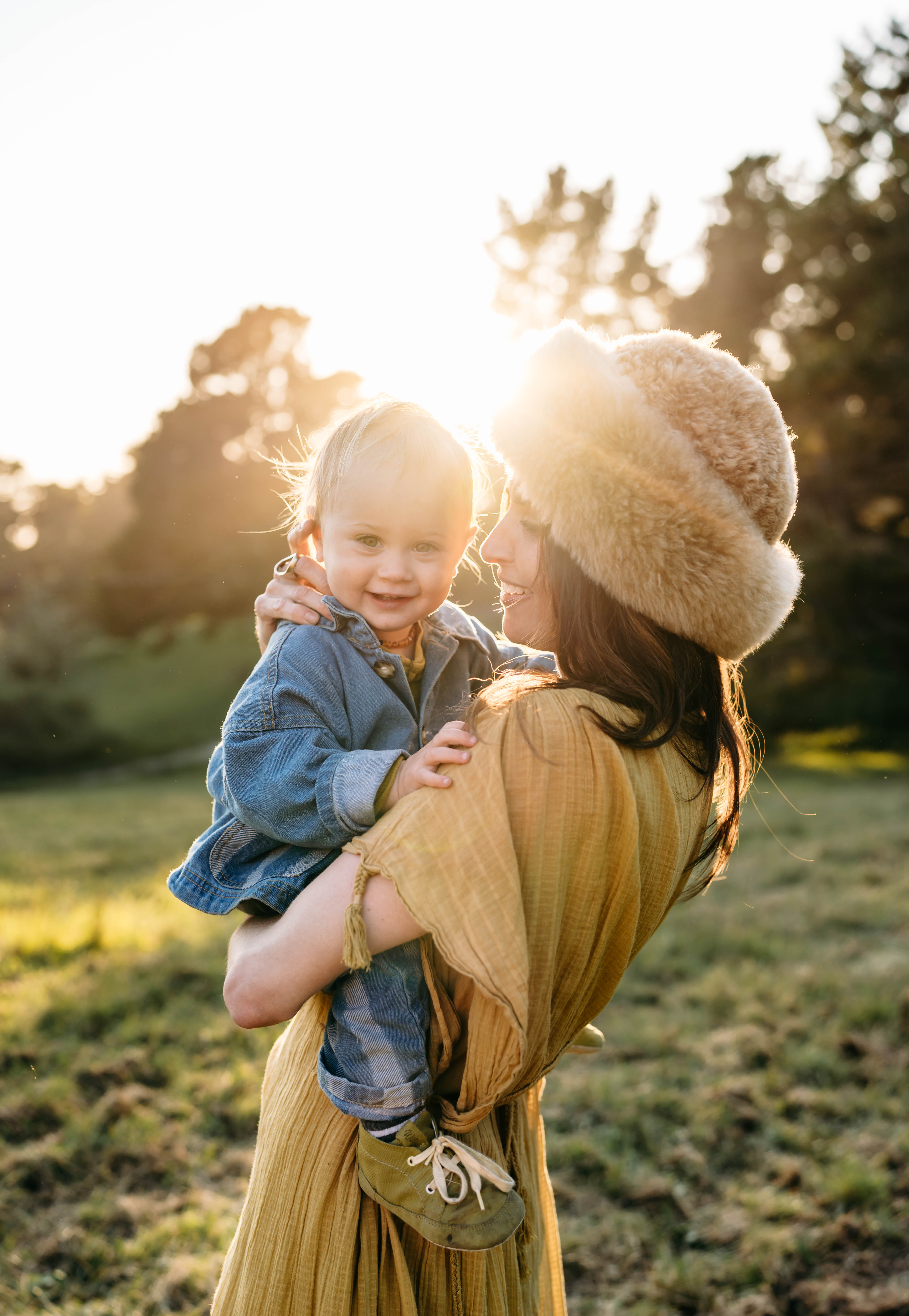 A mother holding her son in late afternoon light