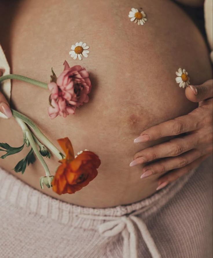 Flowers resting on a pregnant belly