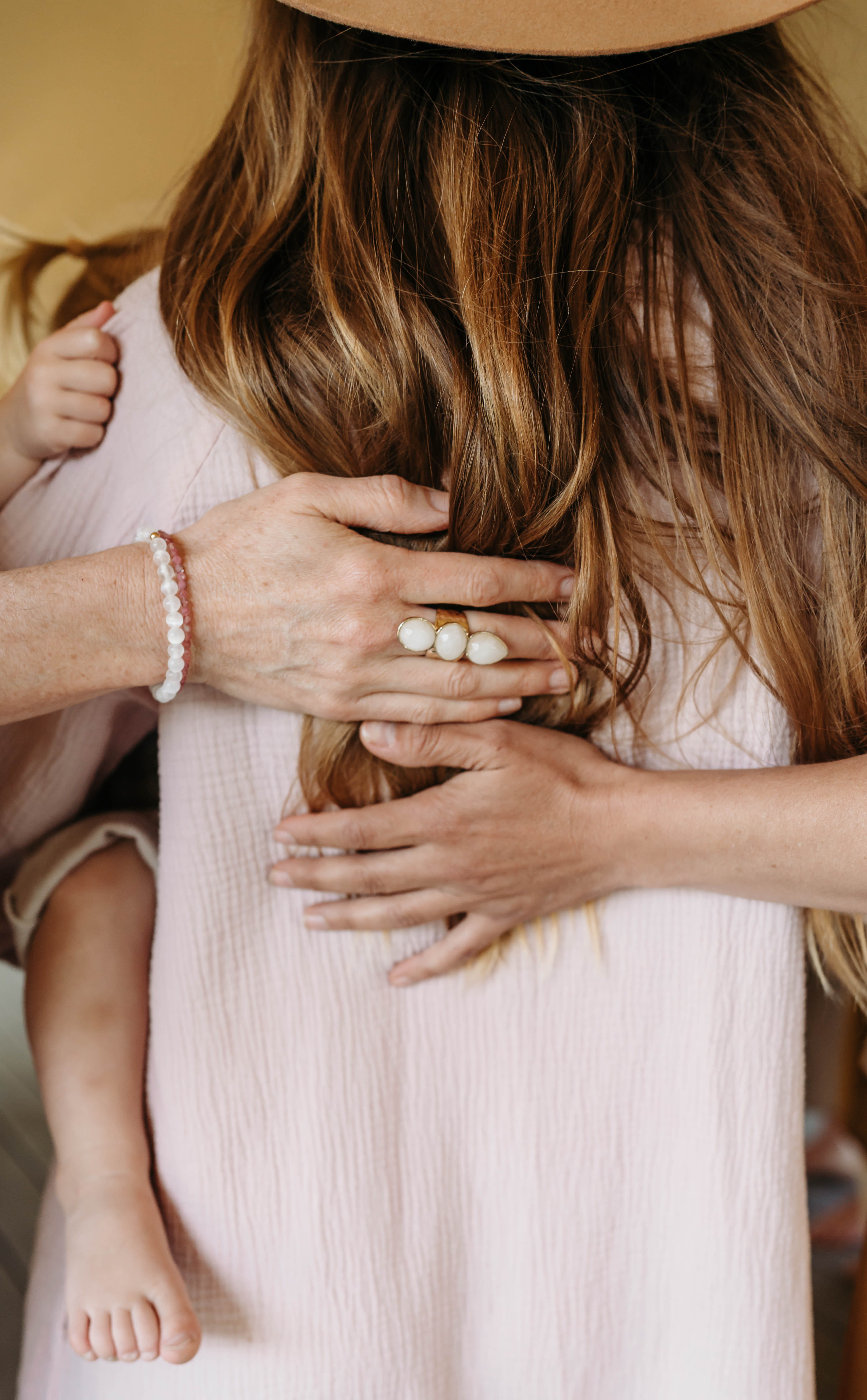 A mother holding her child, arms wrapped around her shoulders